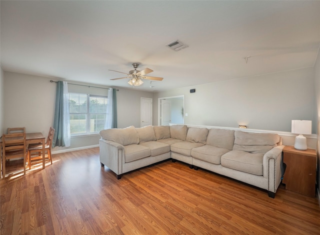 living room with ceiling fan and light hardwood / wood-style flooring