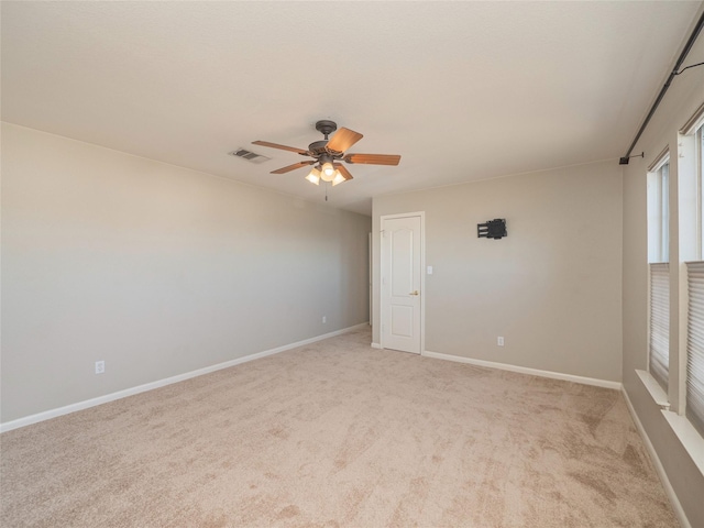 spare room with ceiling fan and light colored carpet