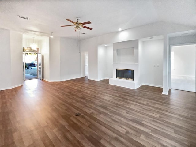 2005 Lark Ln, Taylor, TX 76574 - unfurnished living room with dark wood-type flooring, a glass covered fireplace, a ceiling fan, and recessed lighting