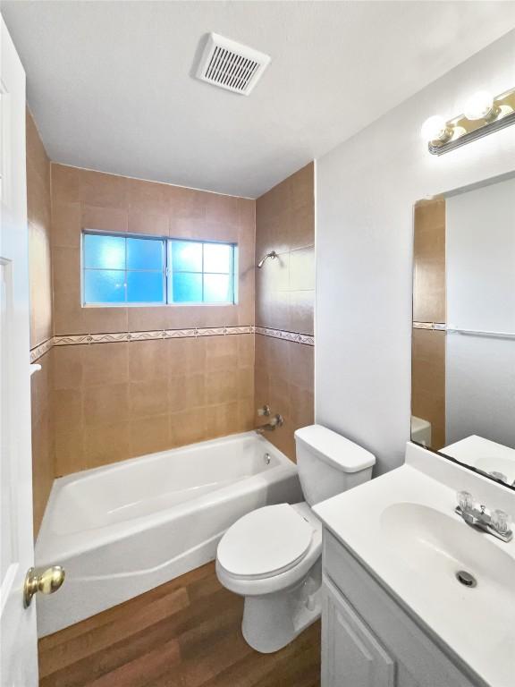 2005 Lark Ln, Taylor, TX 76574 - bathroom featuring wood finished floors, shower / washtub combination, and vanity