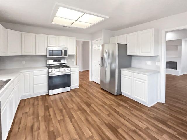 kitchen with white cabinetry, stainless steel appliances, and dark hardwood / wood-style floors