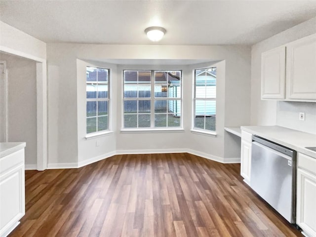 2005 Lark Ln, Taylor, TX 76574 - kitchen with stainless steel dishwasher, dark wood-style floors, light countertops, and white cabinetry