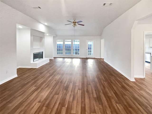 unfurnished living room featuring built in shelves, dark wood-type flooring, ceiling fan, and vaulted ceiling