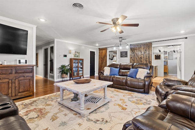 living room with wood-type flooring, ornamental molding, and ceiling fan