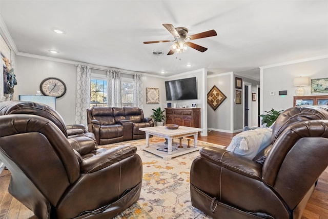 living room with crown molding, light hardwood / wood-style flooring, and ceiling fan