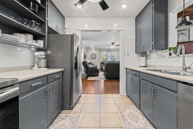 kitchen featuring light tile patterned flooring, sink, decorative light fixtures, ceiling fan, and stainless steel appliances