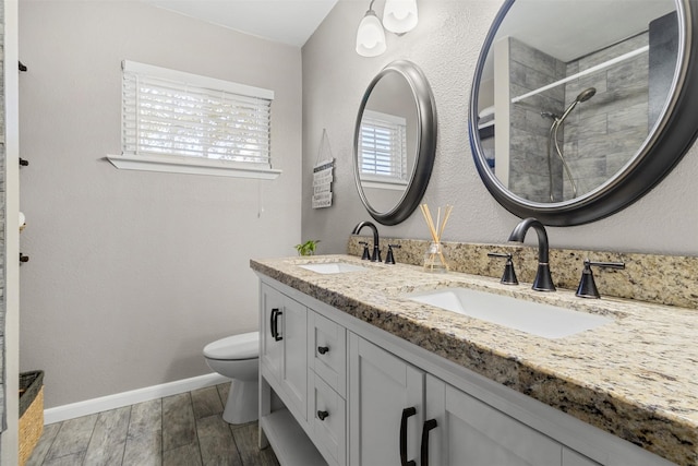 bathroom with vanity, toilet, and a tile shower