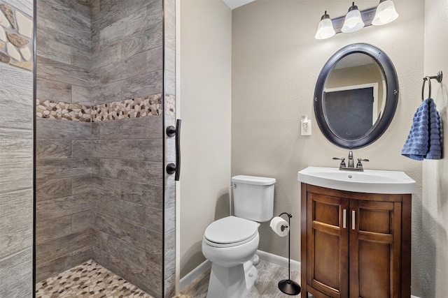 bathroom with vanity, hardwood / wood-style flooring, toilet, and tiled shower