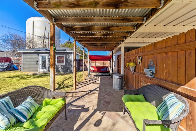 view of patio with an outdoor living space and a storage shed