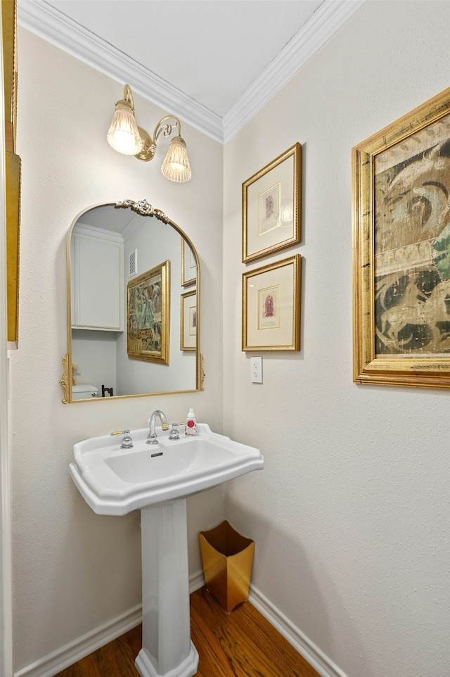 bathroom with hardwood / wood-style flooring and ornamental molding