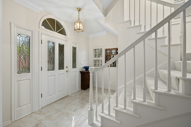 foyer entrance featuring crown molding and a chandelier