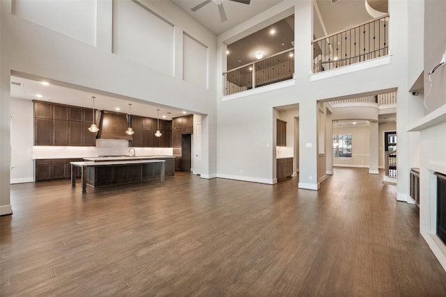 5801 Davenport Divide Rd, Austin, TX 78738 - living area with a high ceiling, ceiling fan, dark wood finished floors, and a glass covered fireplace