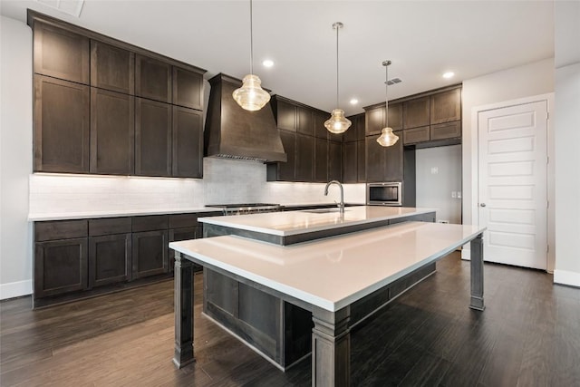 5801 Davenport Divide Rd, Austin, TX 78738 - kitchen with custom range hood, a sink, dark wood finished floors, light countertops, and backsplash