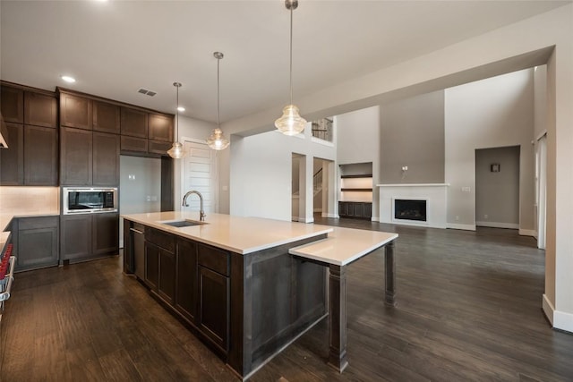 5801 Davenport Divide Rd, Austin, TX 78738 - kitchen with a sink, stainless steel microwave, dark brown cabinets, recessed lighting, and light countertops