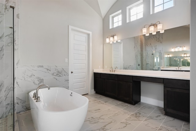 bathroom featuring lofted ceiling, plus walk in shower, vanity, and tile walls