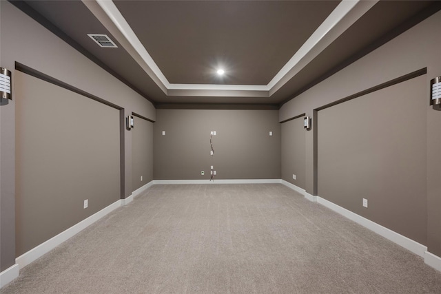 cinema with light colored carpet and a tray ceiling