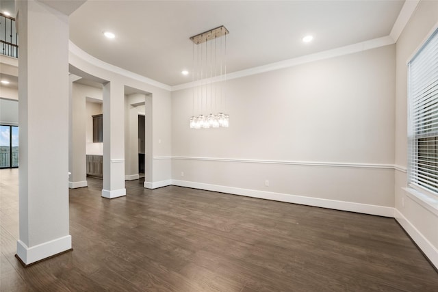 spare room with ornamental molding and dark hardwood / wood-style floors