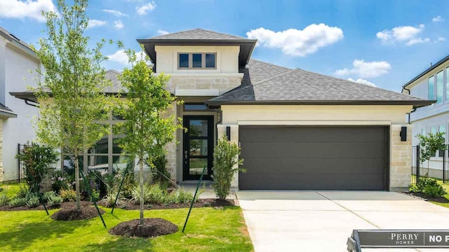 128 La Venta Loop, Liberty Hill, TX 78642 - view of front of house featuring stucco siding, stone siding, driveway, roof with shingles, and an attached garage