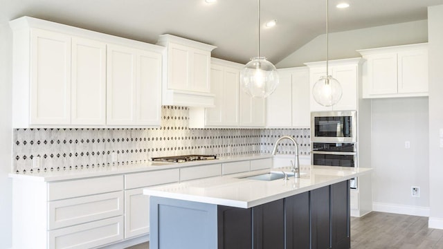 128 La Venta Loop, Liberty Hill, TX 78642 - kitchen featuring appliances with stainless steel finishes, decorative backsplash, light countertops, light wood-style flooring, and white cabinetry
