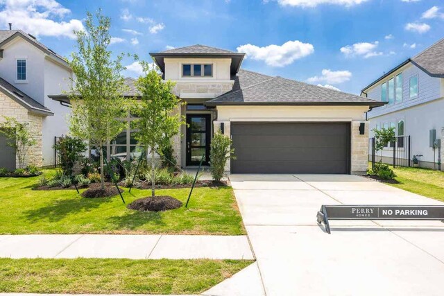 128 La Venta Loop, Liberty Hill, TX 78642 - view of front of house with a garage, driveway, a front lawn, stucco siding, and roof with shingles