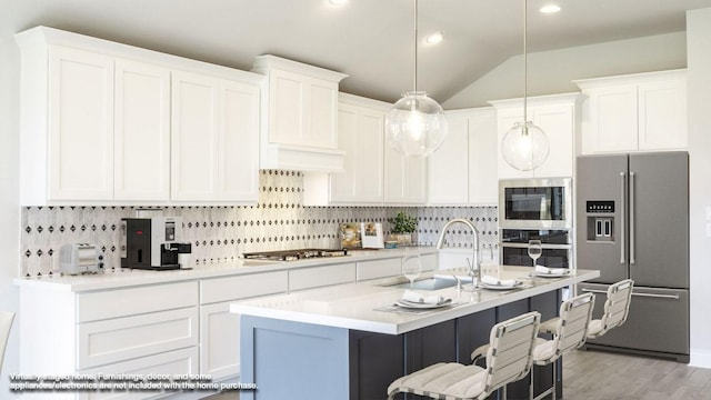 128 La Venta Loop, Liberty Hill, TX 78642 - kitchen with stainless steel appliances, backsplash, light countertops, white cabinetry, and lofted ceiling