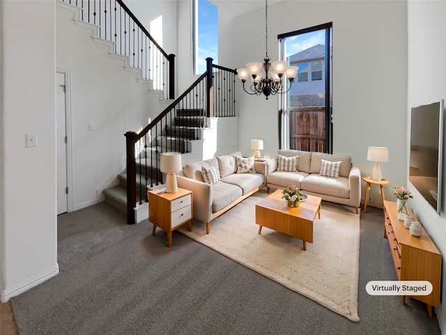 living room featuring a towering ceiling, a chandelier, and dark colored carpet