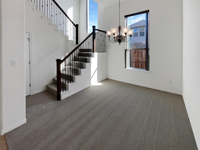 interior space with carpet, a towering ceiling, and a notable chandelier