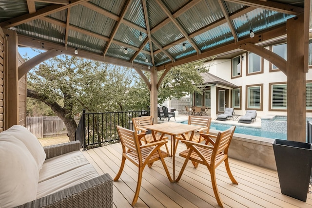 wooden deck with a gazebo, outdoor lounge area, and a fenced in pool