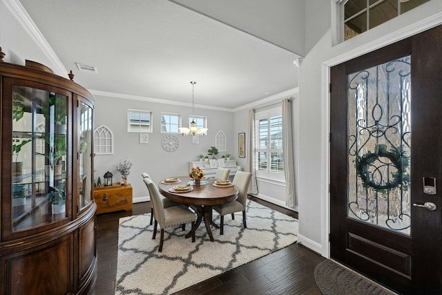 foyer entrance with crown molding, a notable chandelier, and dark hardwood / wood-style flooring