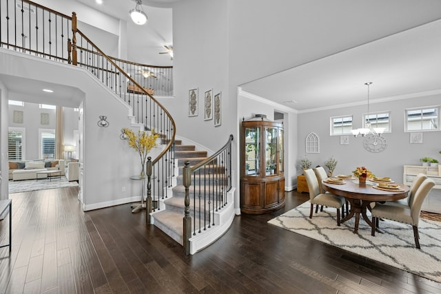 interior space with a notable chandelier, hardwood / wood-style flooring, and ornamental molding