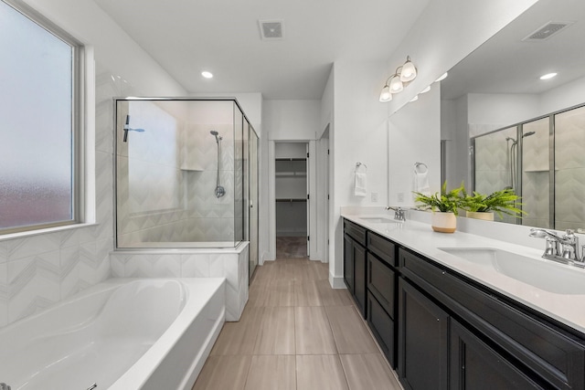 bathroom featuring vanity, independent shower and bath, and tile patterned flooring