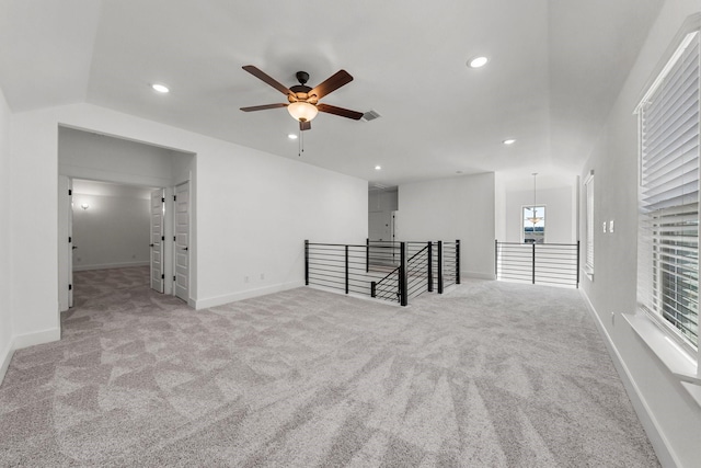 empty room with vaulted ceiling, light carpet, and ceiling fan