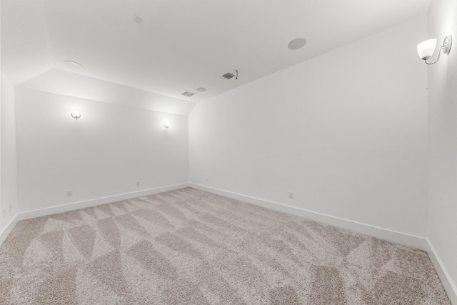 carpeted empty room featuring lofted ceiling