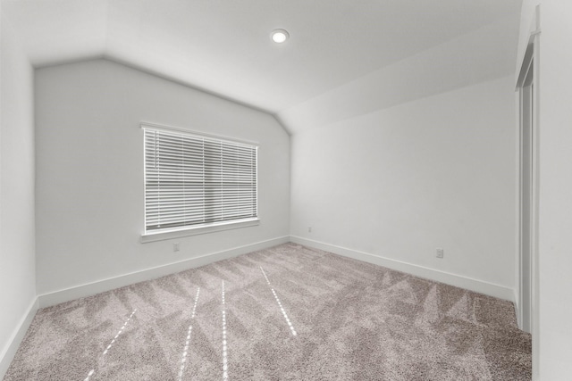 carpeted empty room with lofted ceiling