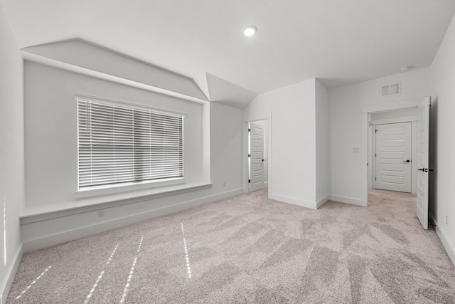 carpeted spare room with lofted ceiling