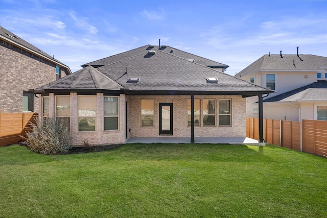 back of house featuring a lawn and a patio area