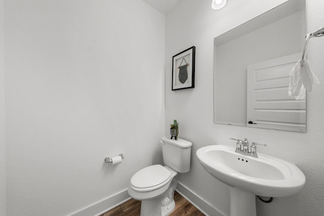 bathroom with hardwood / wood-style floors, sink, and toilet