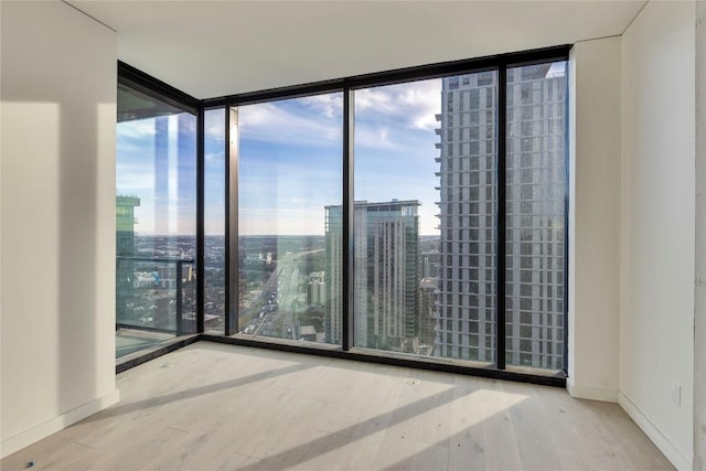 empty room featuring expansive windows and wood-type flooring