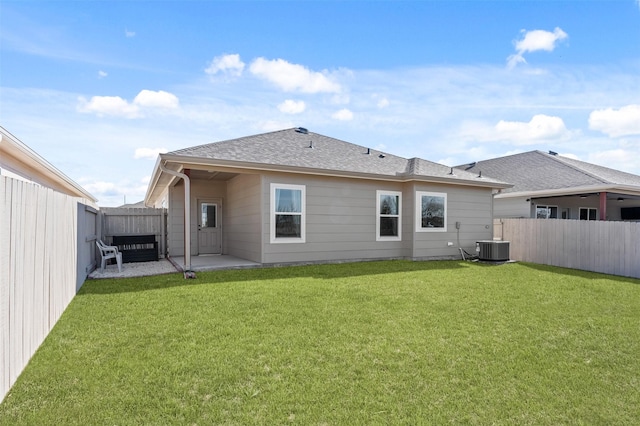 back of house featuring cooling unit, a yard, and a patio