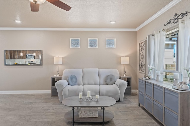 living room featuring ceiling fan, ornamental molding, and a textured ceiling