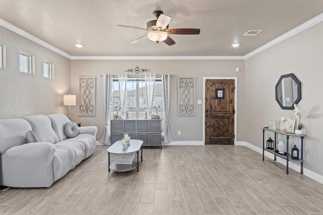 living room featuring crown molding, ceiling fan, and a textured ceiling