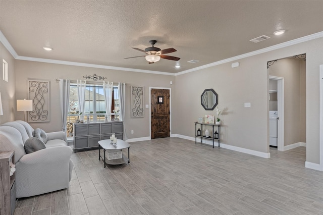 living room featuring ceiling fan, washer / dryer, crown molding, and a textured ceiling