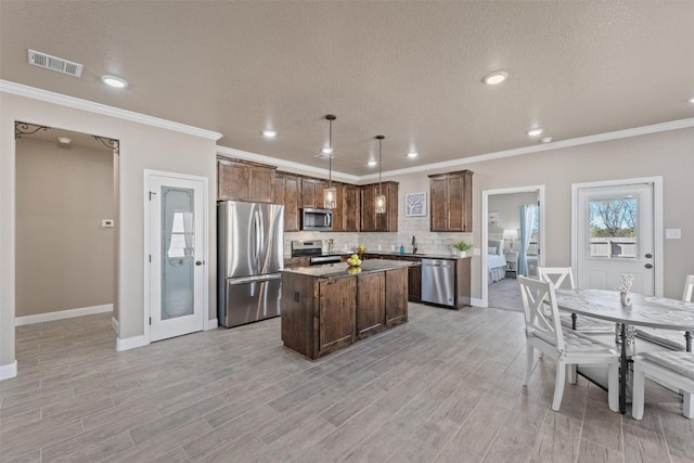 3608 Oglala Trl, Temple, TX 76502 - kitchen featuring stainless steel appliances, backsplash, light wood-style flooring, a kitchen island, and recessed lighting