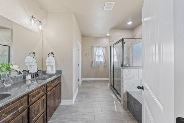 bathroom featuring vanity, a textured ceiling, and separate shower and tub