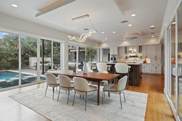 dining area featuring sink and light hardwood / wood-style floors