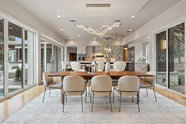 dining room featuring a notable chandelier and light hardwood / wood-style flooring