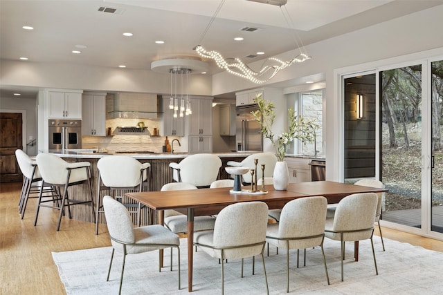 dining space featuring sink and light hardwood / wood-style flooring