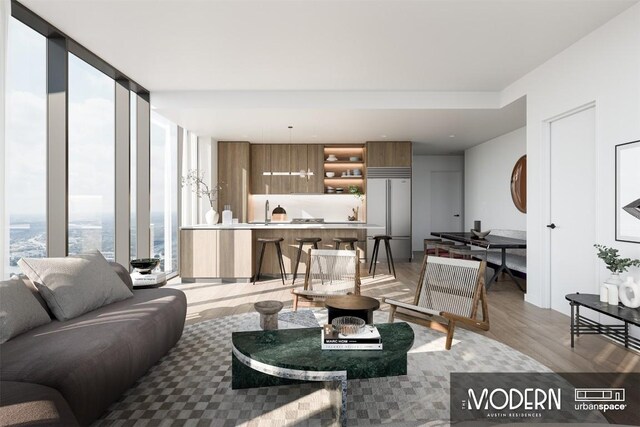 living room featuring expansive windows, sink, and light hardwood / wood-style floors