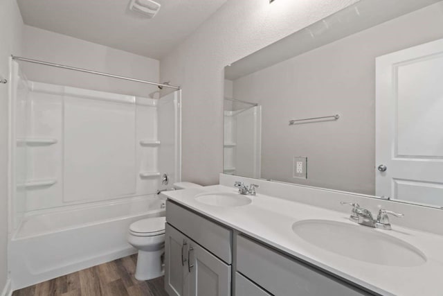 full bathroom featuring wood-type flooring, toilet, bathing tub / shower combination, and vanity