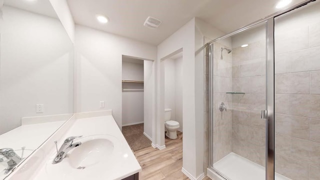 bathroom with vanity, wood-type flooring, an enclosed shower, and toilet